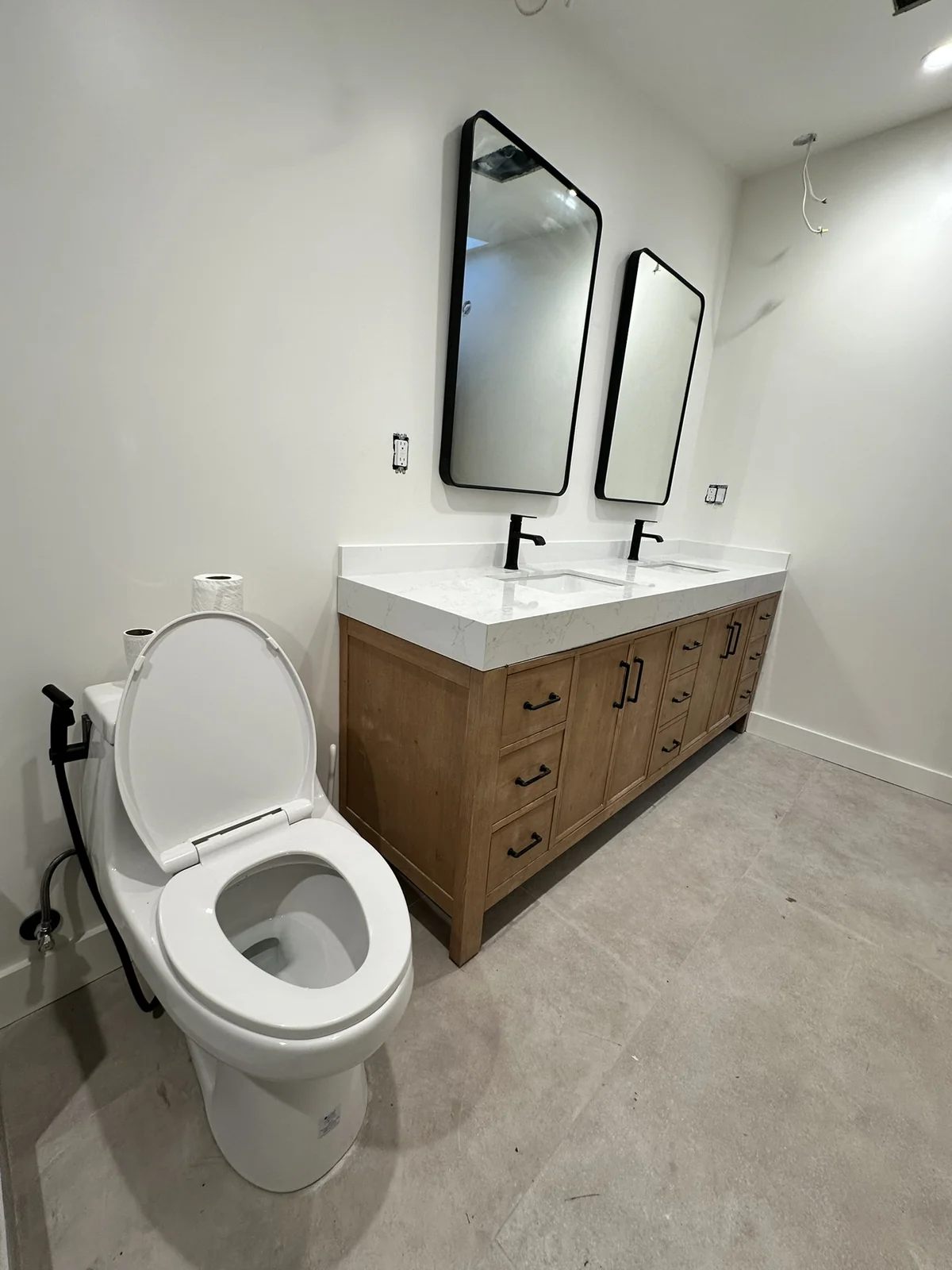 Bathroom with a wood double vanity, white countertop, two sinks and two framed mirrors