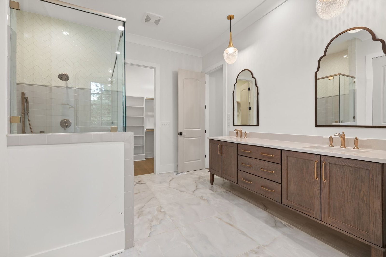 Bathroom with a double vanity, drawers, mirrors and glass shower