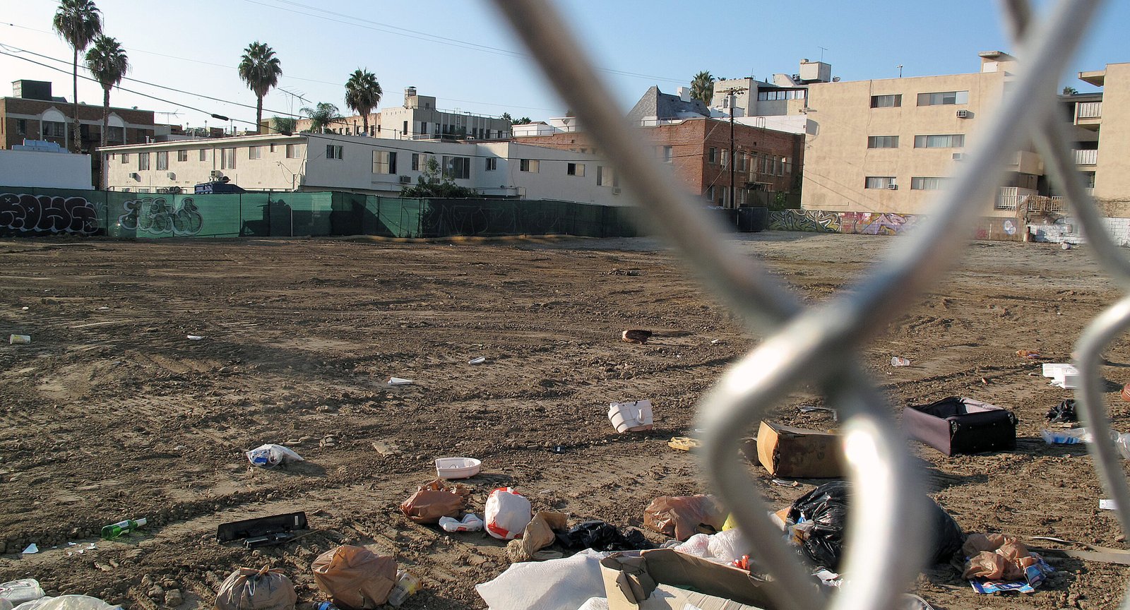 Vacant urban lot viewed through a chain-link fence