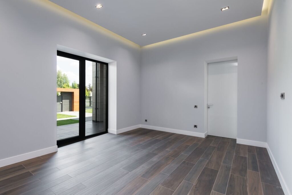 Empty finished room with wood-look flooring and large glass doors