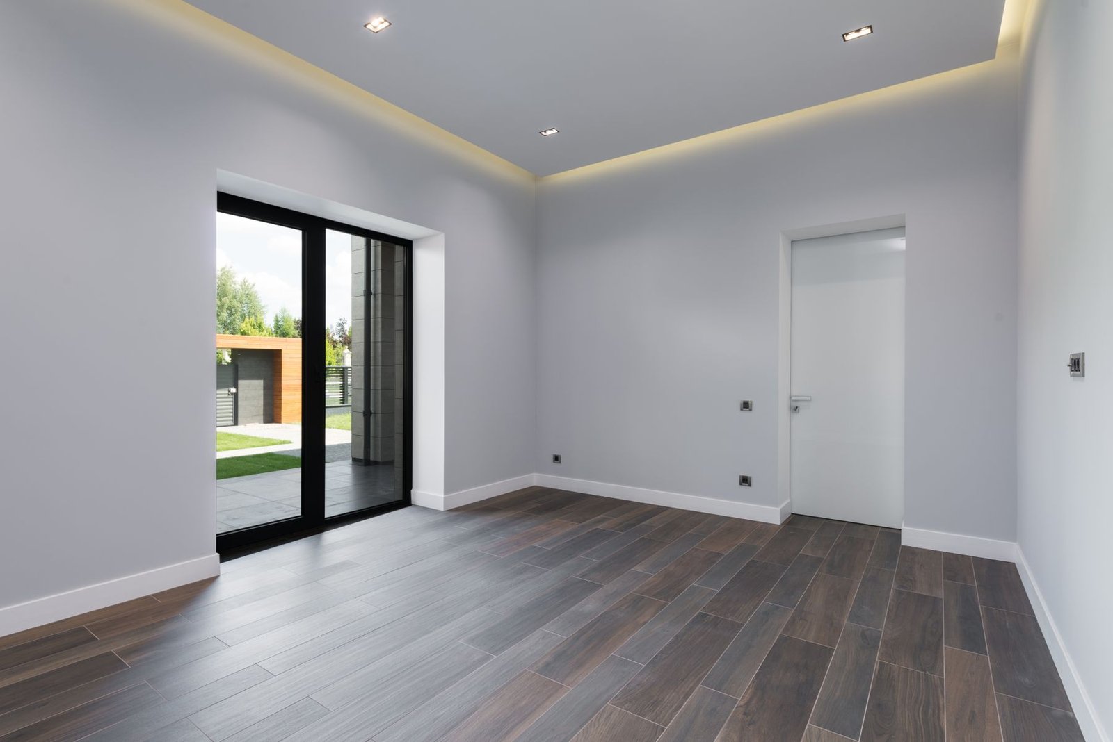 Empty finished room with wood-look flooring and large glass doors