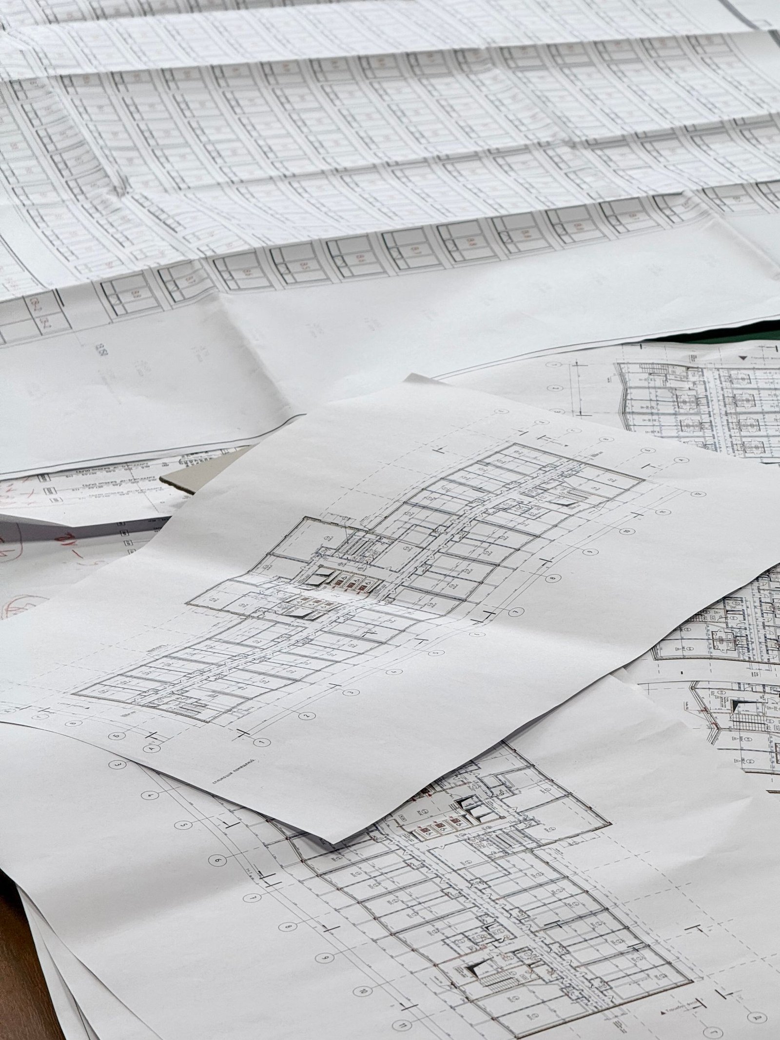 Several sheets of architectural plans spread across a table