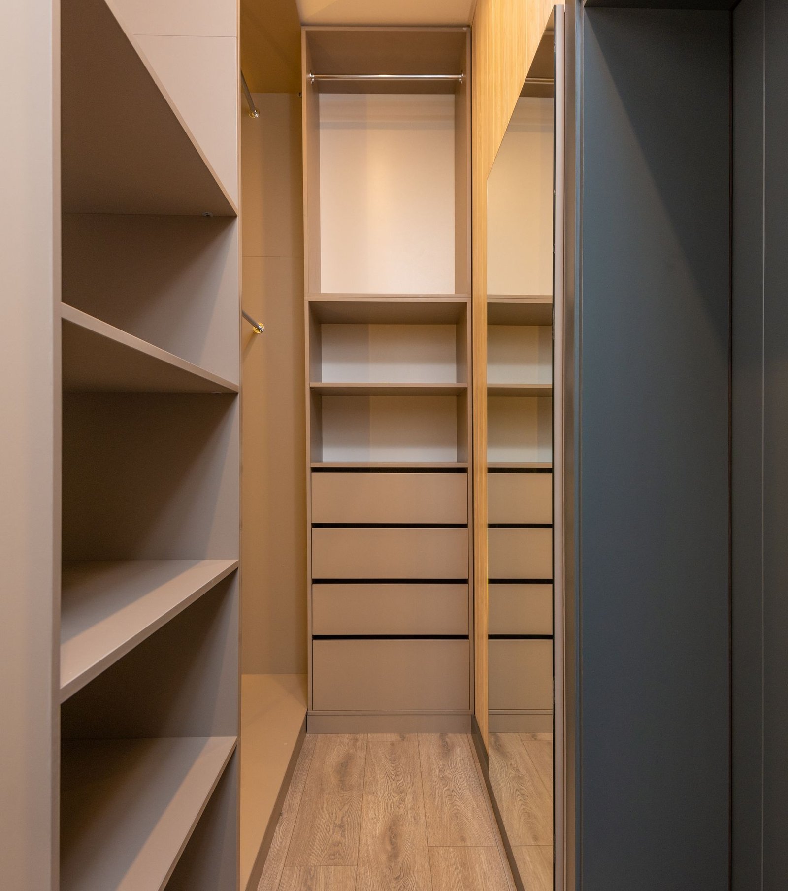 Fitted wardrobe beside a narrow wood-floored circulation space.