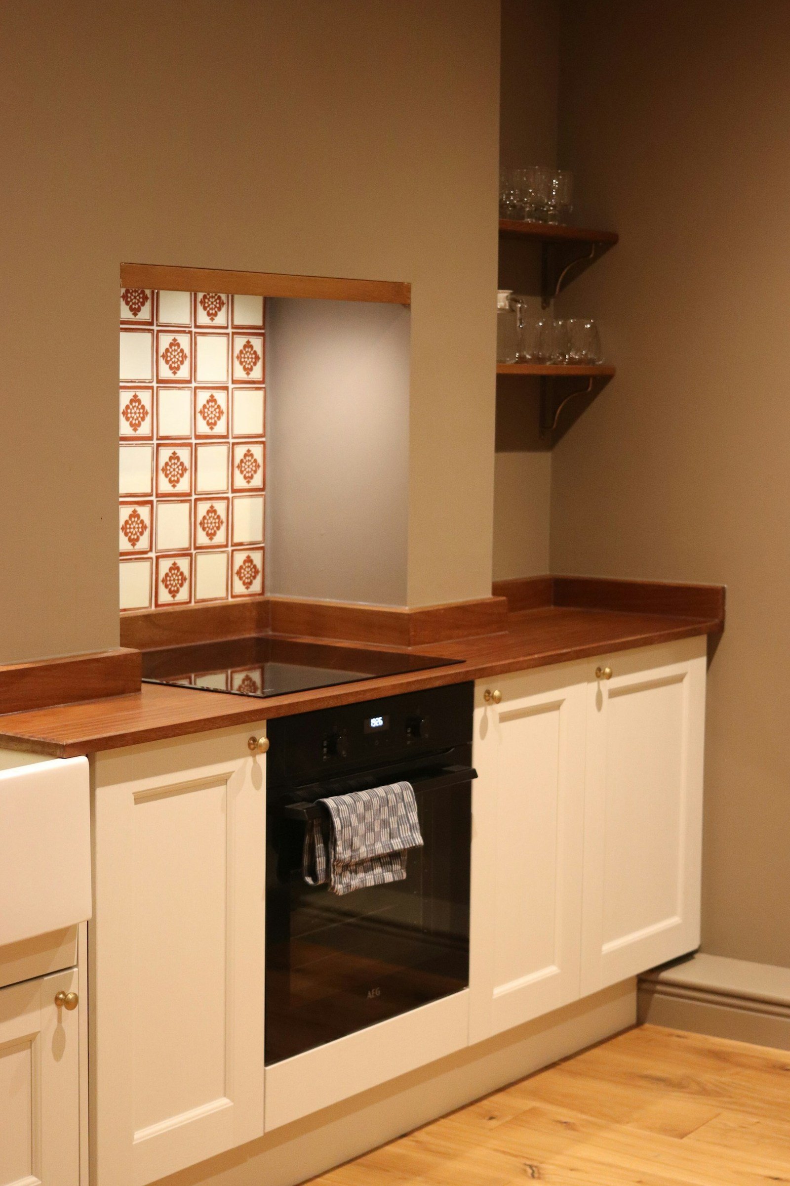 Compact kitchen with white cabinets, wooden counters and an oven