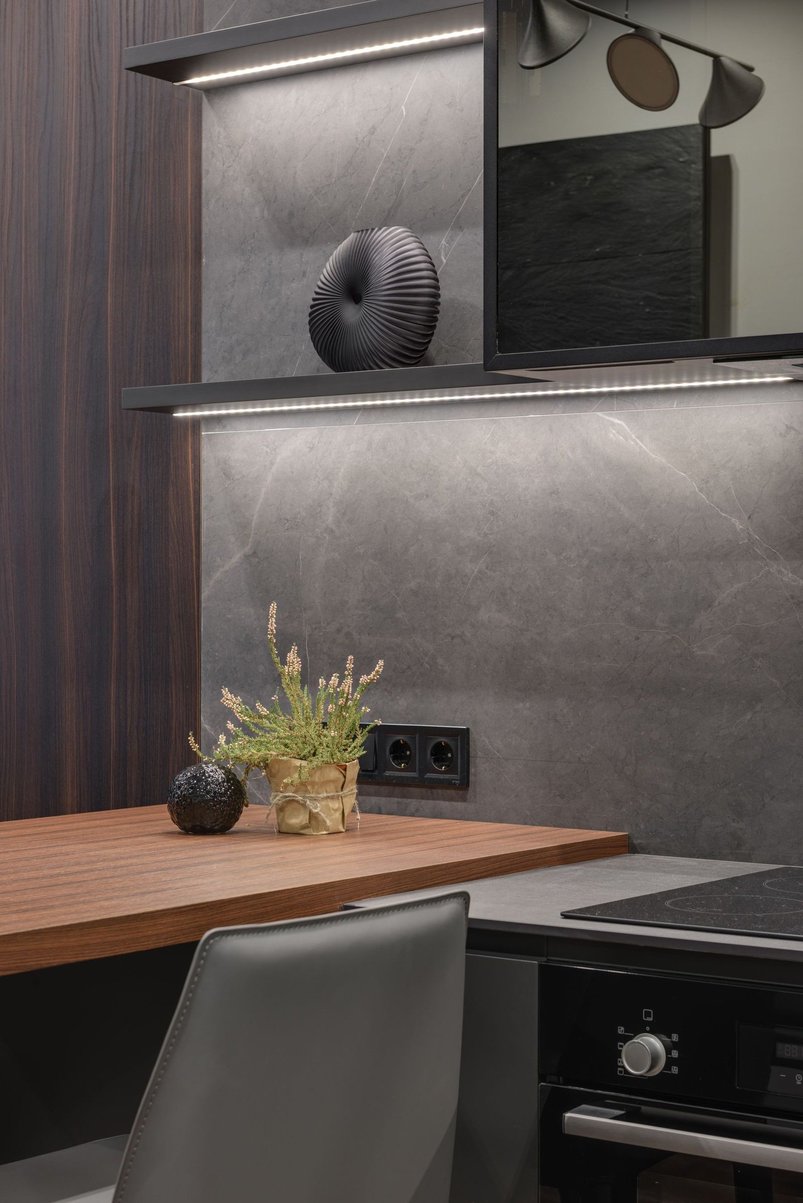 Wood countertop, dark kitchen cabinets and illuminated open shelves