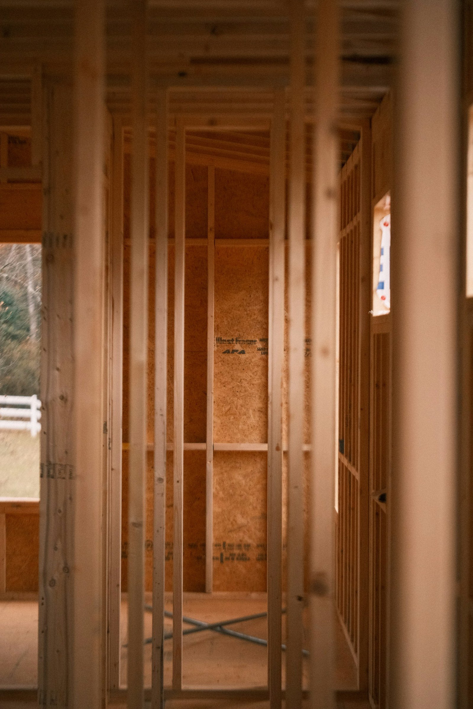 Wooden wall studs and overhead joists inside a home under construction