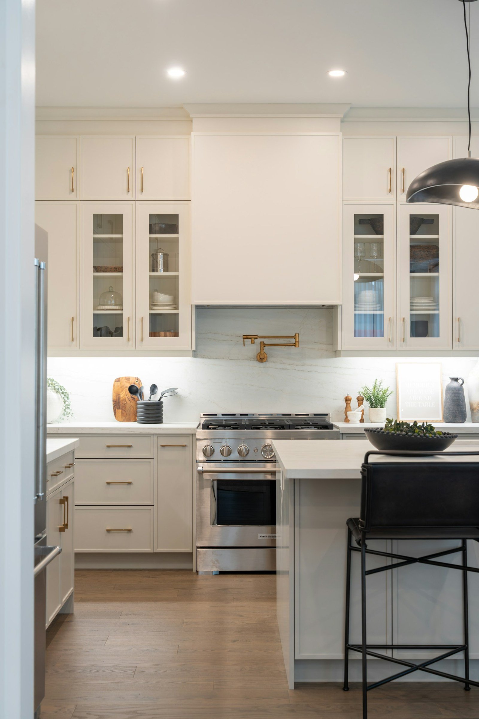 White residential kitchen with island seating and stainless steel appliances