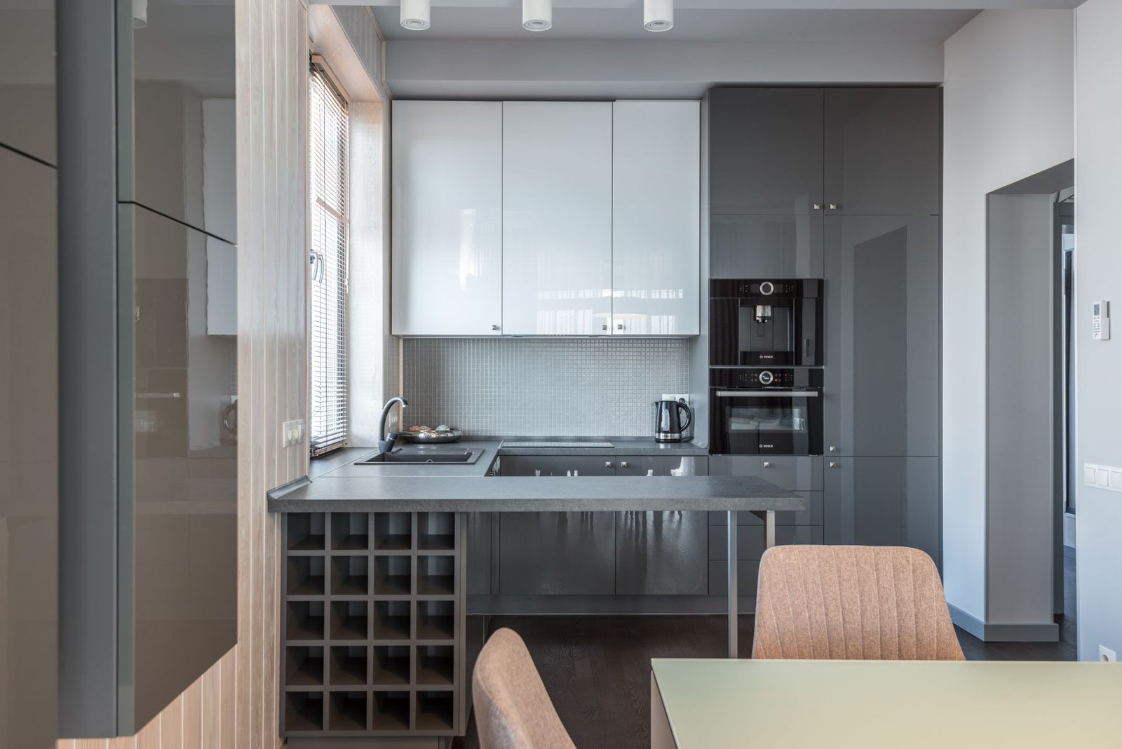 Compact gray kitchen with cabinetry, an island and adjacent seating space.