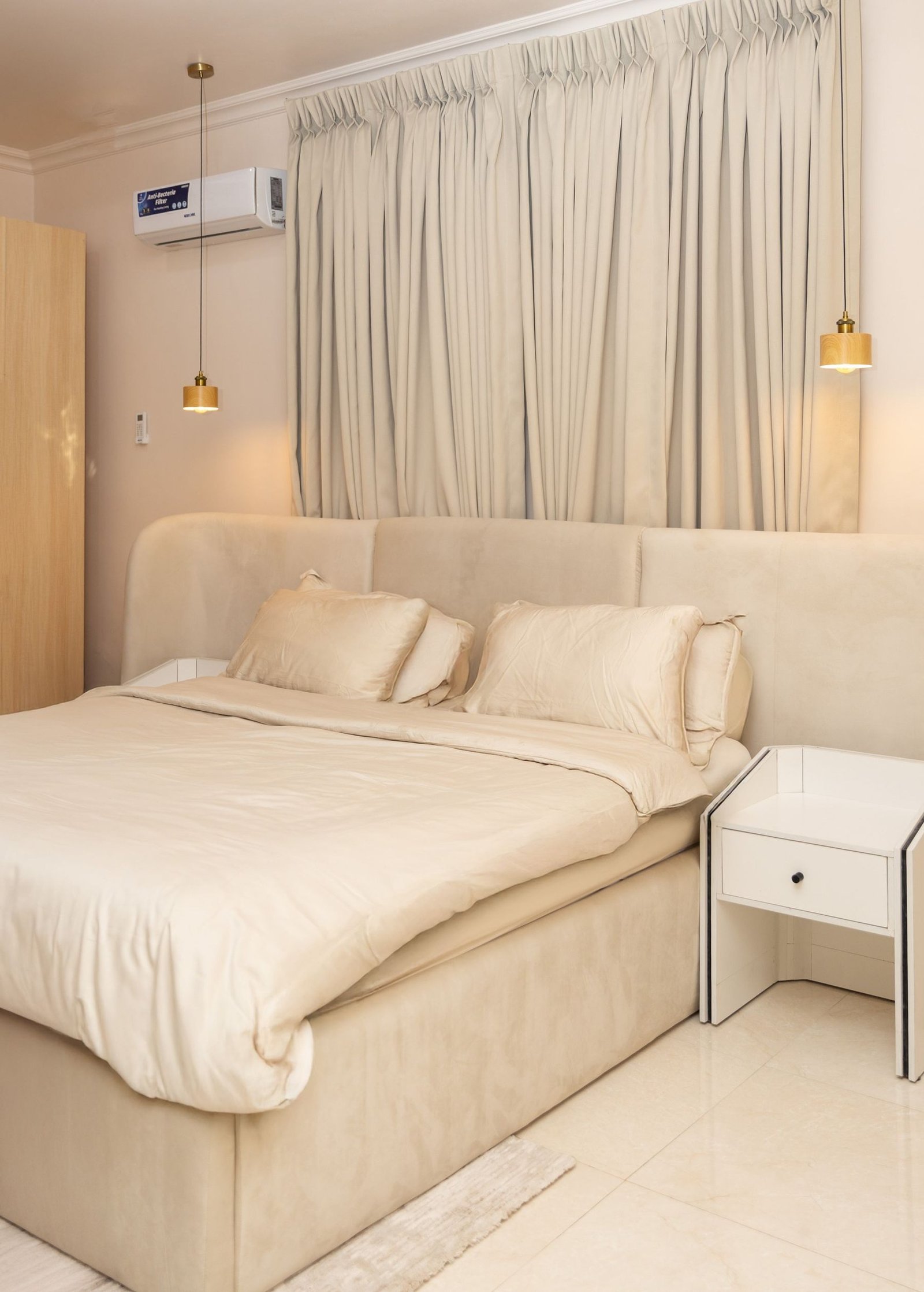Bedroom with a bed, curtains and a wall-mounted air conditioner.