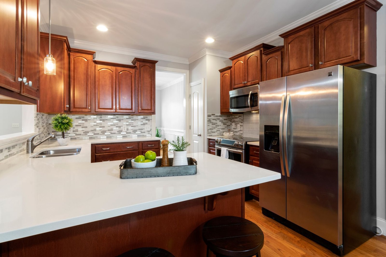Kitchen with wood cabinetry, a white counter and refrigerator.