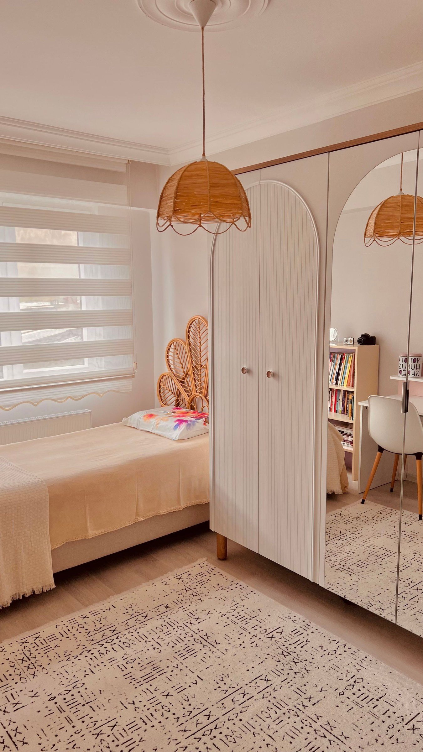 Bedroom with a woven pendant light, shelving and a mirrored wardrobe.