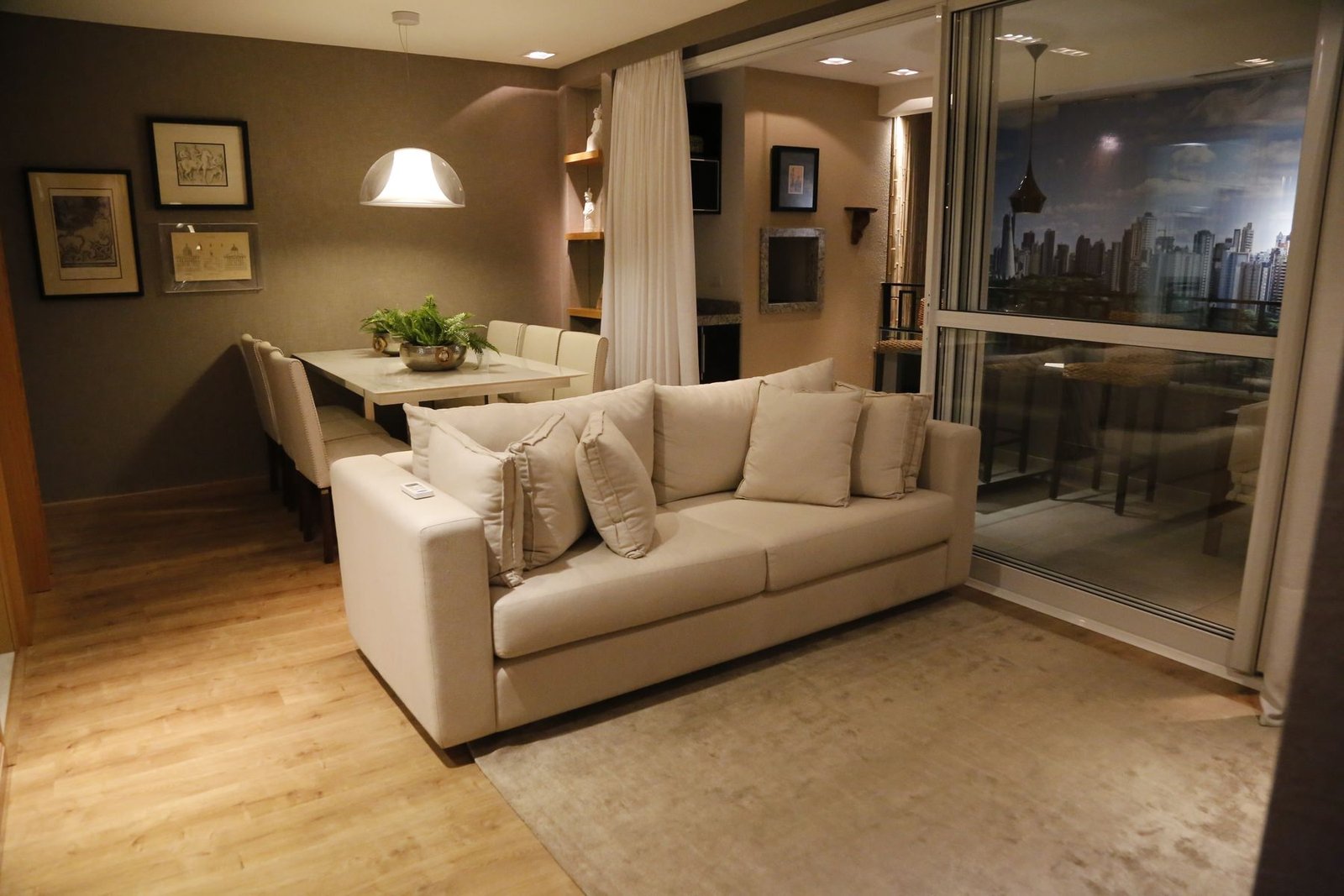Living and dining space with a sofa, dining table and glazed balcony doors.