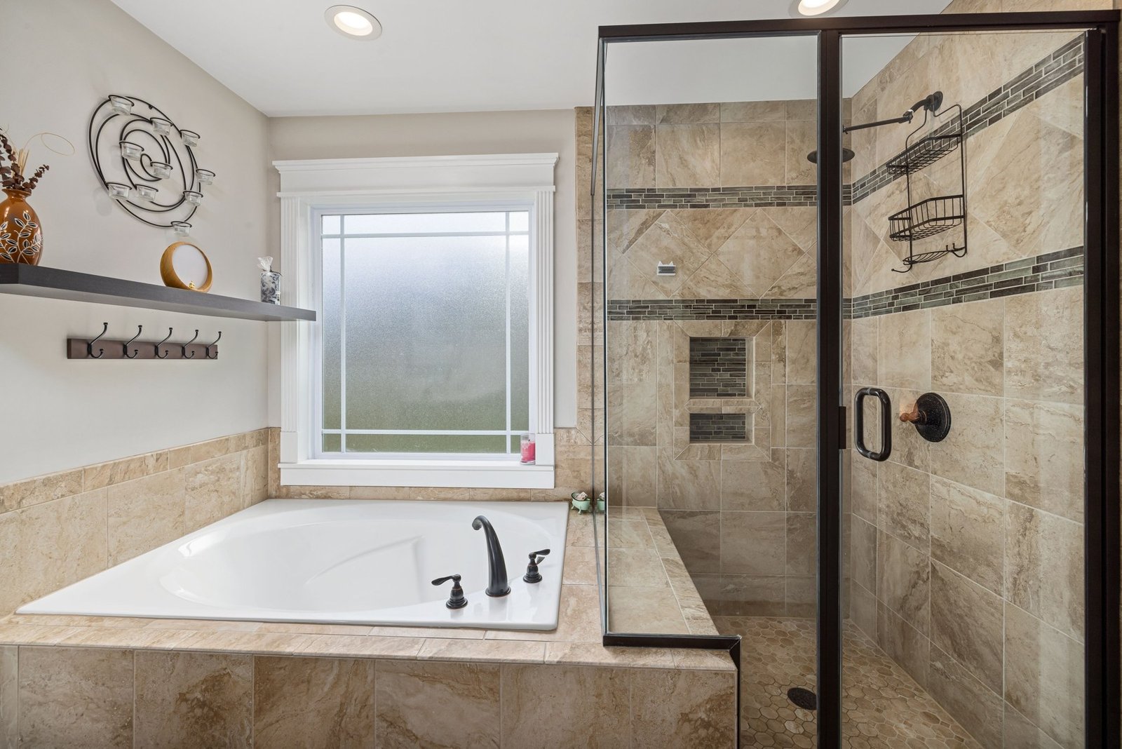 Bathroom with a tiled bathtub surround, glass shower and frosted window