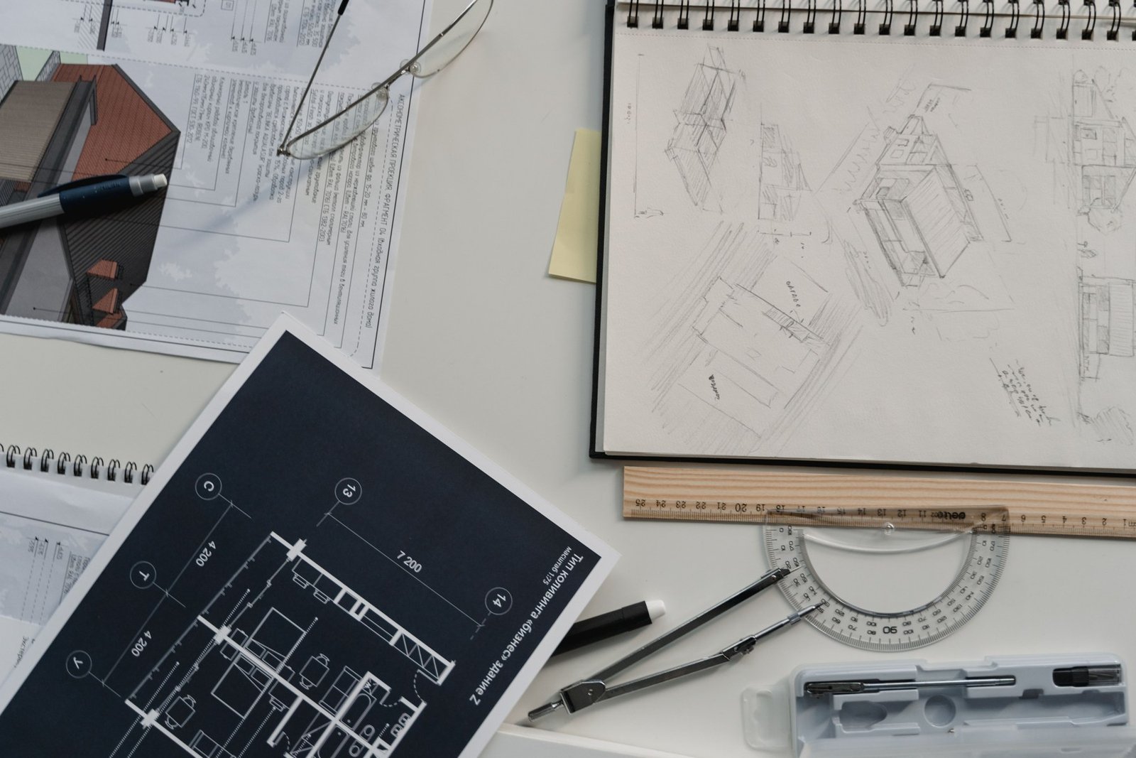 Architectural sketches and printed drawings with rulers and drafting tools