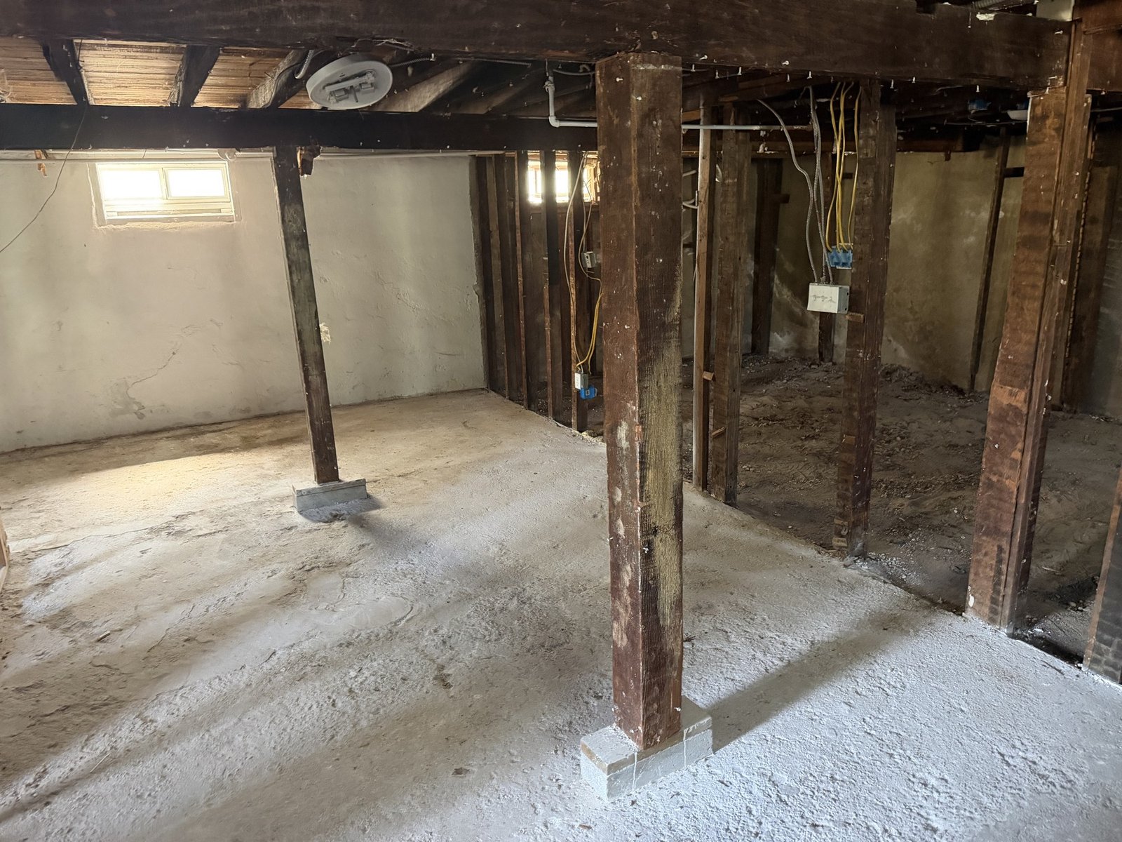 Open interior with existing wood posts and wall framing above a concrete floor