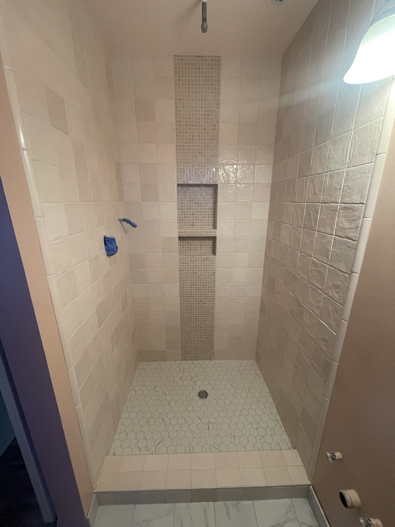 Tiled shower walls with a recessed niche and small-format shower-floor tile
