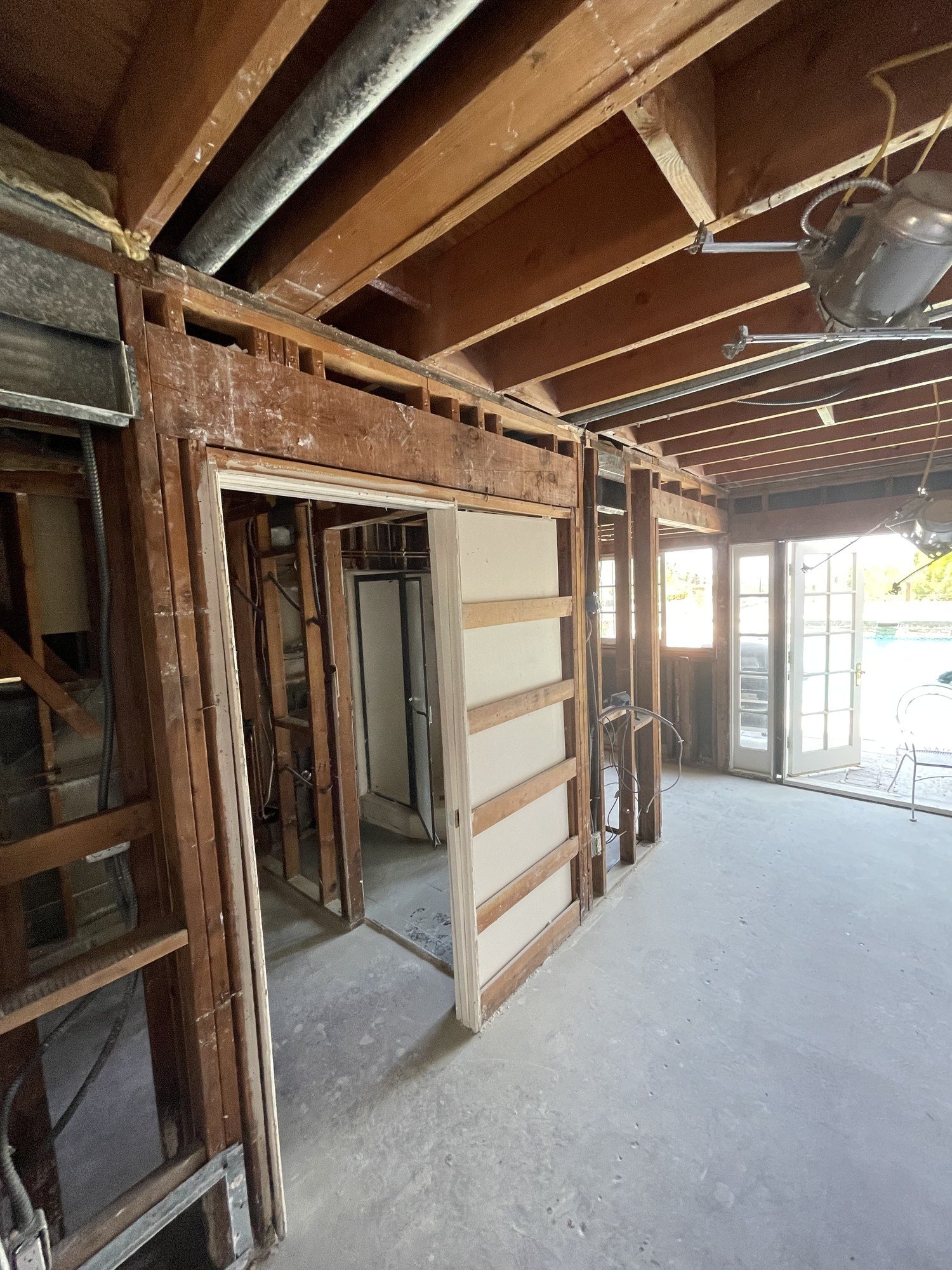 Exposed wood ceiling and wall framing around an existing doorway between interior spaces