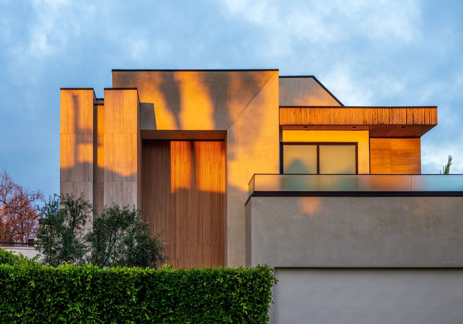 Contemporary home with broad glazing and warm sunset reflections