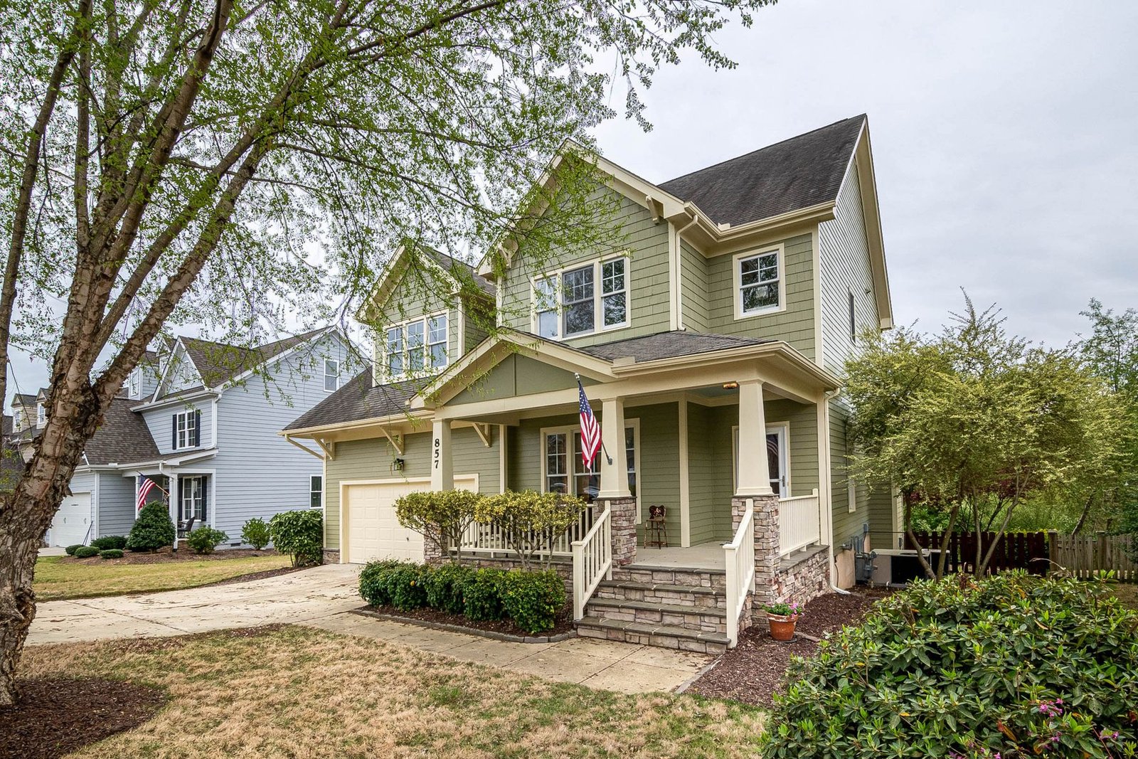 Traditional home with a front porch, garden and flag