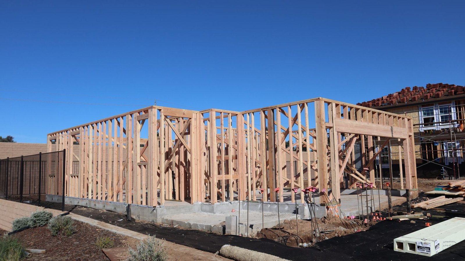New timber-framed home under construction beneath a blue sky