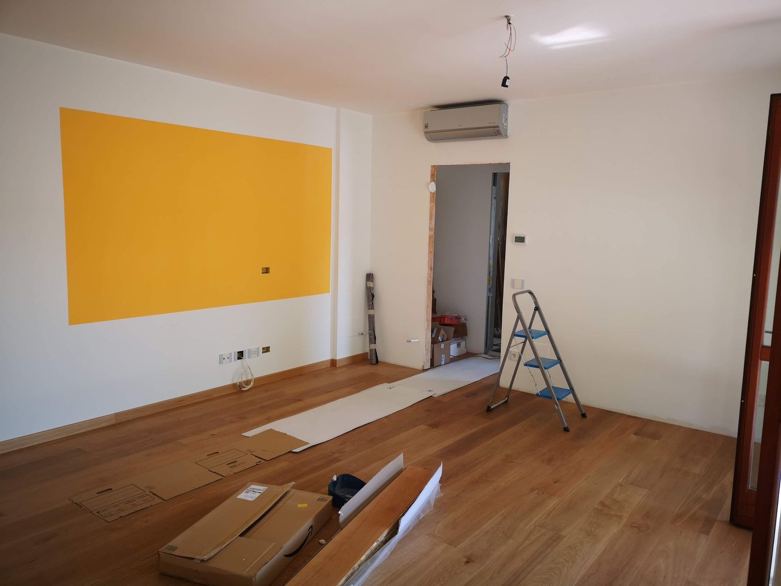 Bright room undergoing renovation with a ladder and construction tools